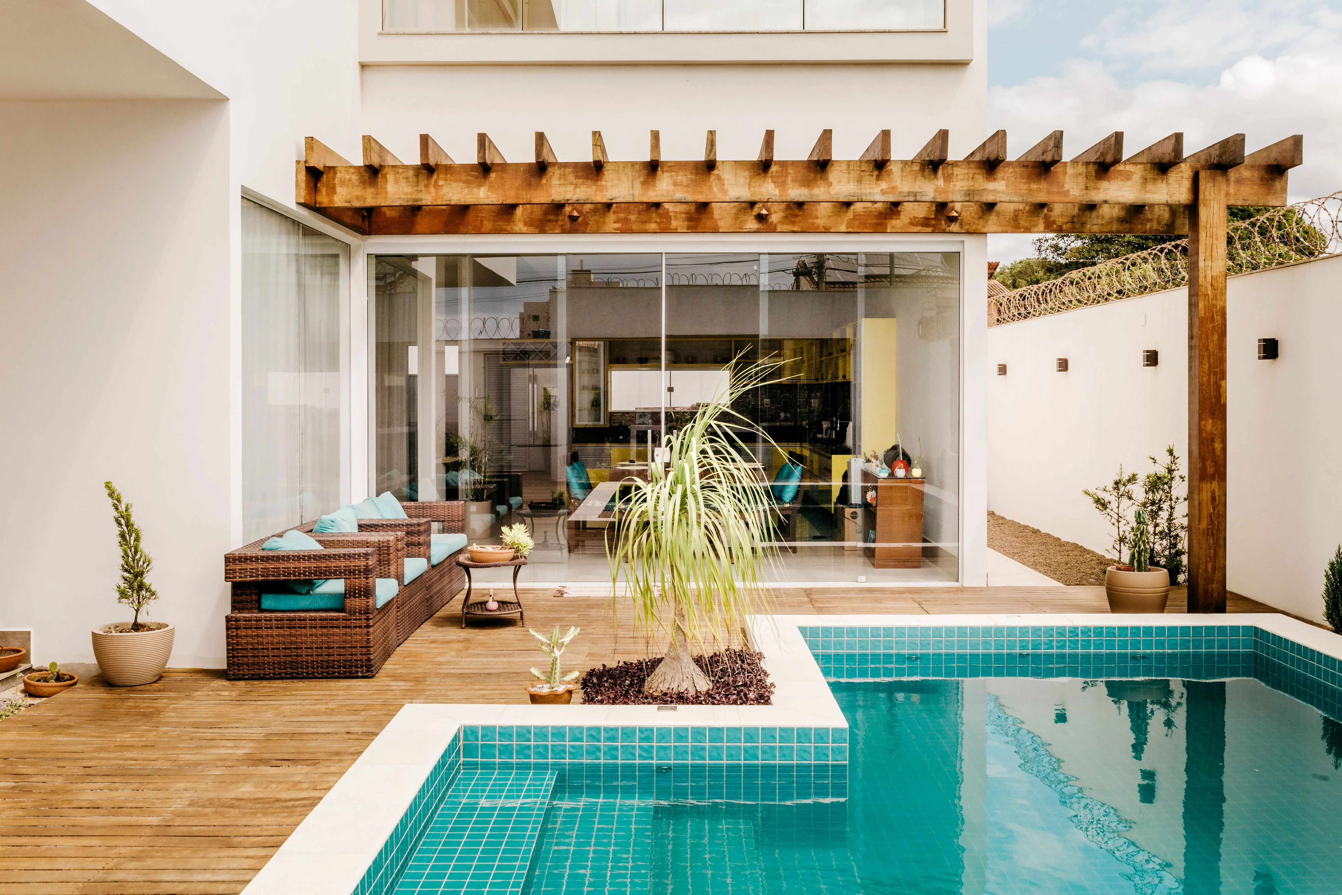 Terrace of Costa Creative Rental with a wooden pergola, lounge seating and a tiled private pool